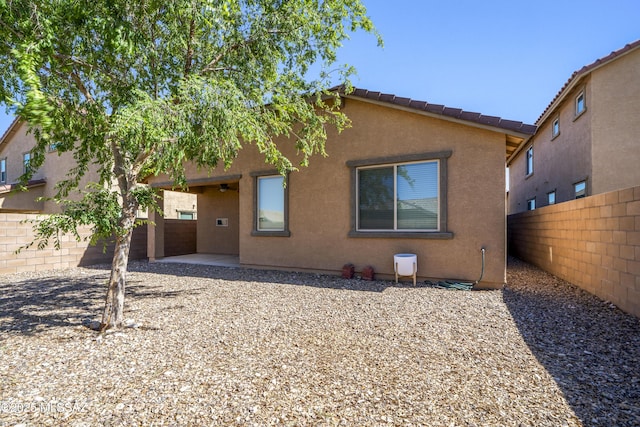 rear view of house with a fenced backyard and stucco siding