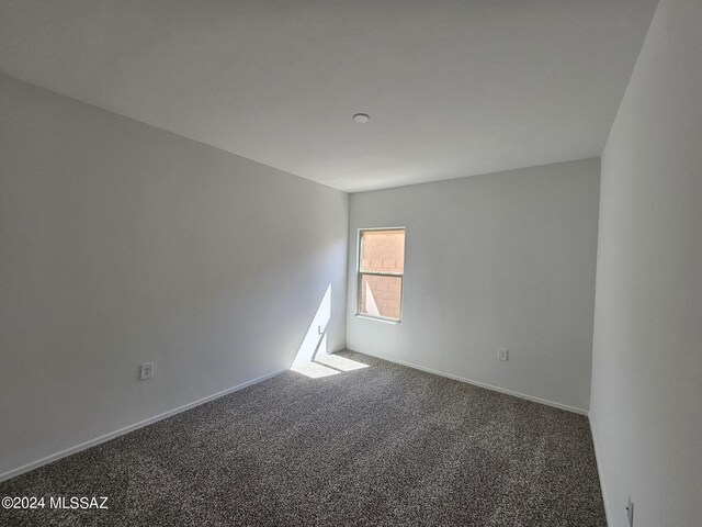 empty room featuring baseboards and carpet