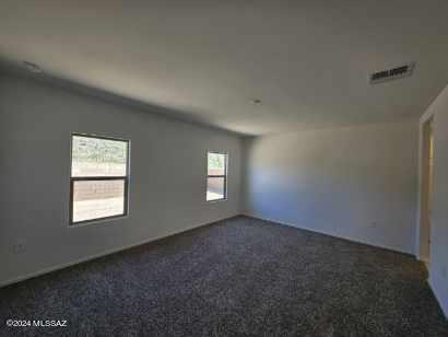 spare room with dark carpet and visible vents