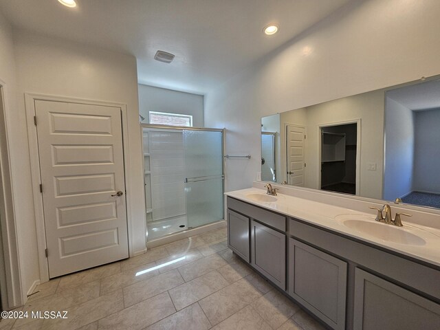 bathroom with a sink, recessed lighting, double vanity, and a stall shower