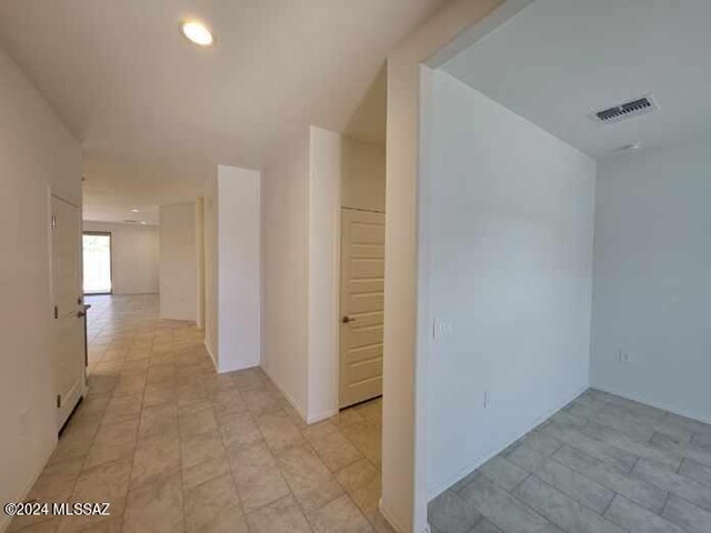 hall with visible vents, recessed lighting, and light tile patterned floors