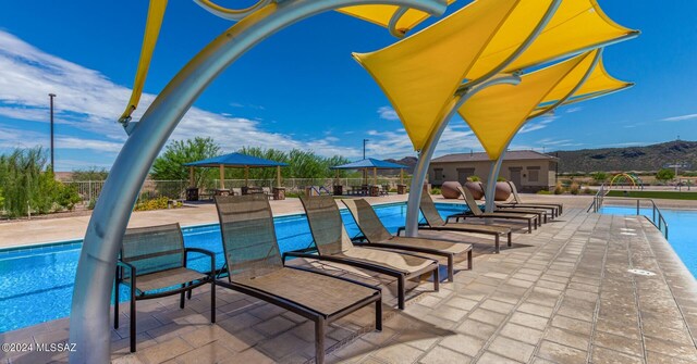pool featuring fence, a patio, and a mountain view