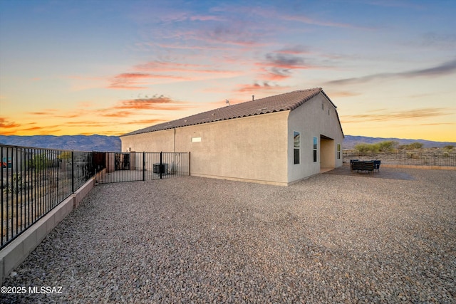 14633 E Old Owl Creek Ct, Vail, AZ 85641 - back of property at dusk with stucco siding, a mountain view, and a tiled roof
