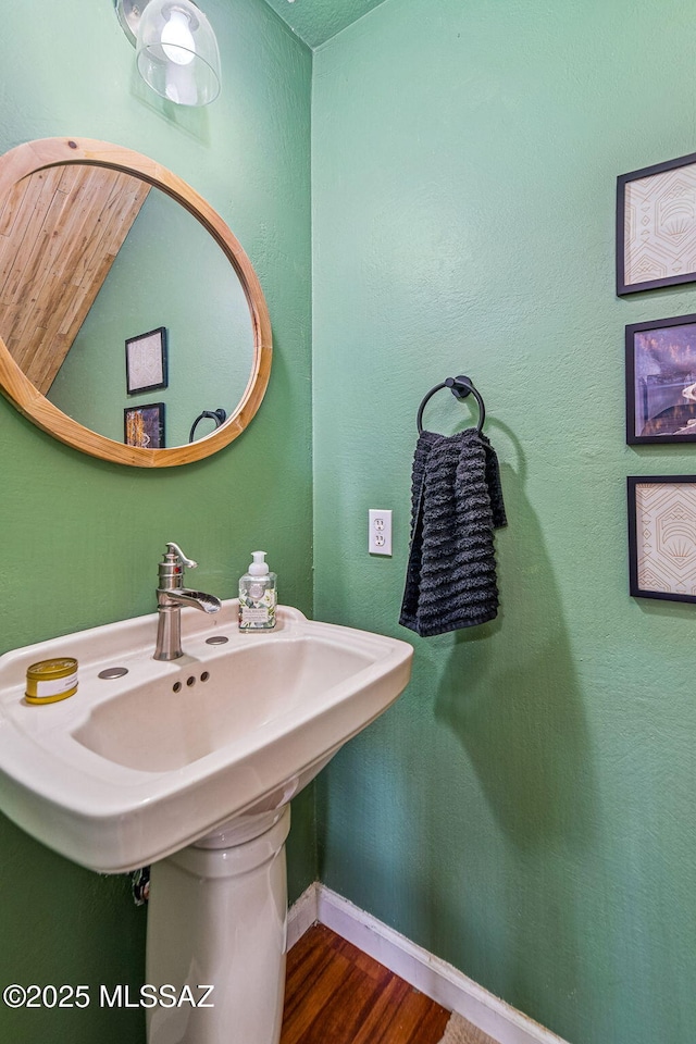 bathroom with baseboards and wood finished floors