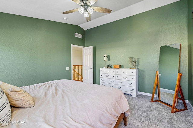 carpeted bedroom featuring a textured wall, ceiling fan, baseboards, vaulted ceiling, and visible vents