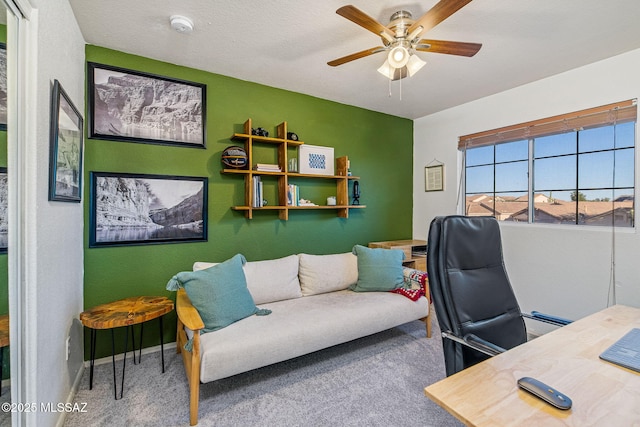 carpeted home office featuring baseboards and a ceiling fan