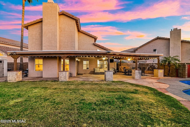 back of property with a yard, a patio, and fence