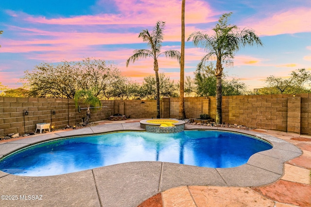 view of swimming pool featuring a patio, a pool with connected hot tub, and a fenced backyard