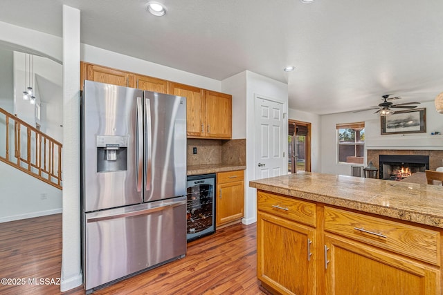 kitchen with ceiling fan, tile counters, beverage cooler, stainless steel refrigerator with ice dispenser, and dark wood-style floors