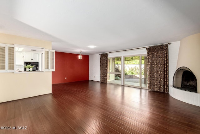 unfurnished living room featuring dark wood finished floors