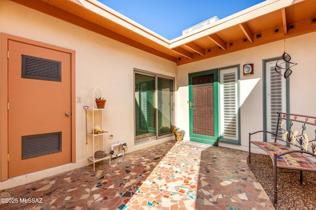 property entrance featuring stucco siding and a patio area