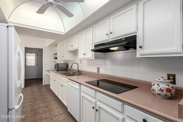 kitchen featuring a ceiling fan, a sink, white cabinets, under cabinet range hood, and white appliances