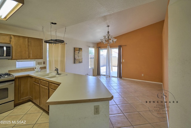 4703 W Gatehinge Ct, Tucson, AZ 85741 - kitchen featuring appliances with stainless steel finishes, a peninsula, a sink, light tile patterned flooring, and a chandelier