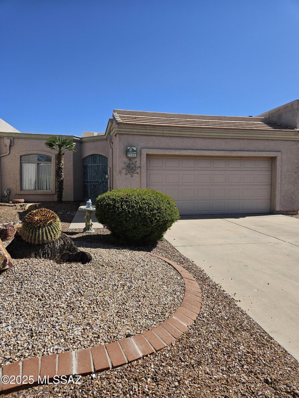 2565 S Pecan Valley Pl, Green Valley, AZ 85614 - view of front facade with concrete driveway, a garage, and stucco siding