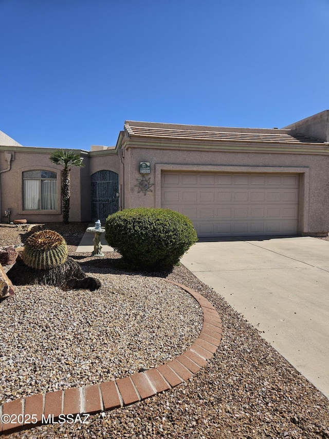 2565 S Pecan Valley Pl, Green Valley, AZ 85614 - view of front facade with concrete driveway, a garage, and stucco siding