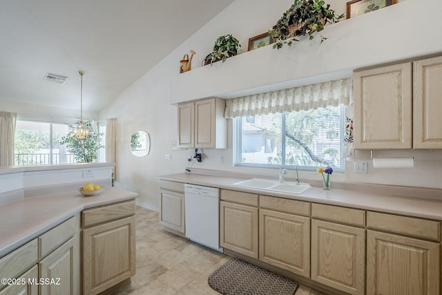 kitchen featuring visible vents, light brown cabinetry, vaulted ceiling, dishwasher, and a sink