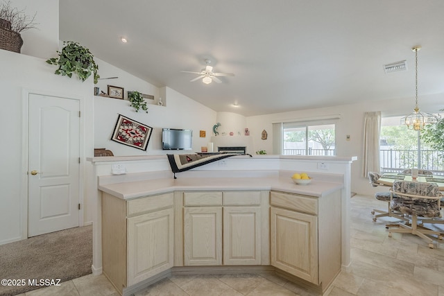 kitchen featuring decorative light fixtures, visible vents, vaulted ceiling, light countertops, and ceiling fan with notable chandelier