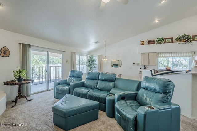 living room with a wealth of natural light, visible vents, ceiling fan, and light colored carpet
