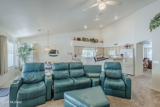 living room with light colored carpet, arched walkways, plenty of natural light, a ceiling fan, and visible vents