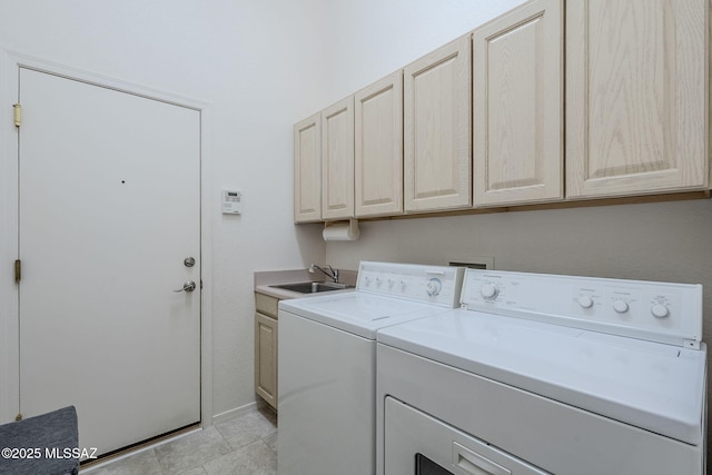 washroom with washer and dryer, cabinet space, a sink, baseboards, and light tile patterned floors