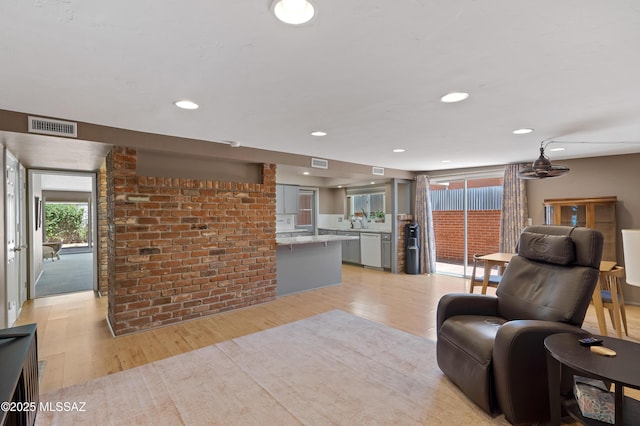 3202 W Calle Cereza, Tucson, AZ 85741 - living area with visible vents, brick wall, light wood finished floors, and recessed lighting