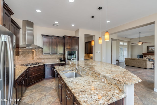 36330 S Desert Sun Dr, Tucson, AZ 85739 - kitchen featuring appliances with stainless steel finishes, wall chimney range hood, a sink, ceiling fan, and decorative backsplash