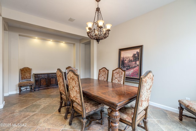 36330 S Desert Sun Dr, Tucson, AZ 85739 - dining space with a chandelier, stone tile floors, and baseboards