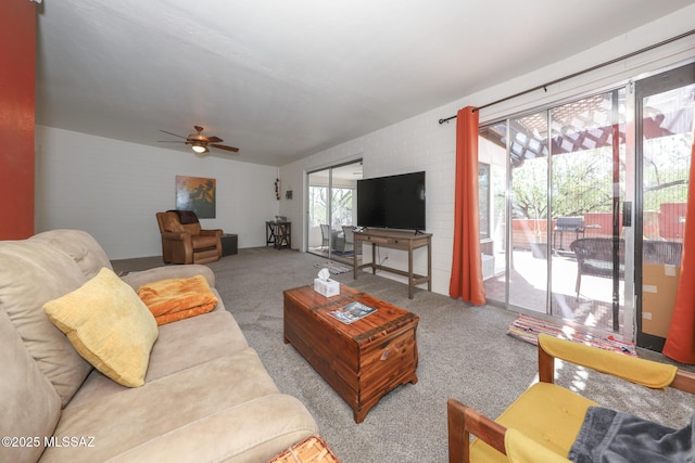 living area featuring a ceiling fan and carpet