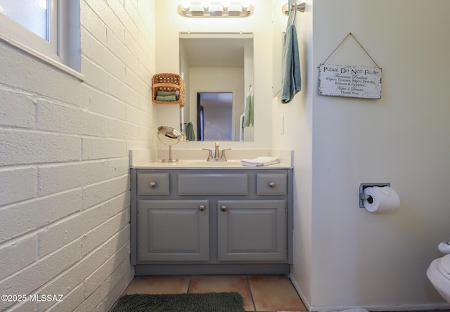 half bathroom featuring tile patterned flooring, toilet, and vanity
