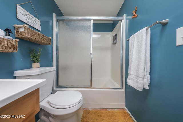 bathroom with vanity, enclosed tub / shower combo, tile patterned floors, and toilet