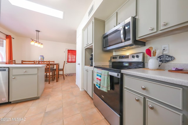 kitchen featuring light countertops, gray cabinets, light tile patterned floors, and stainless steel appliances