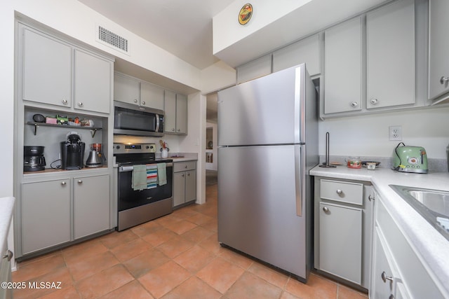 kitchen with light countertops, gray cabinets, stainless steel appliances, and visible vents