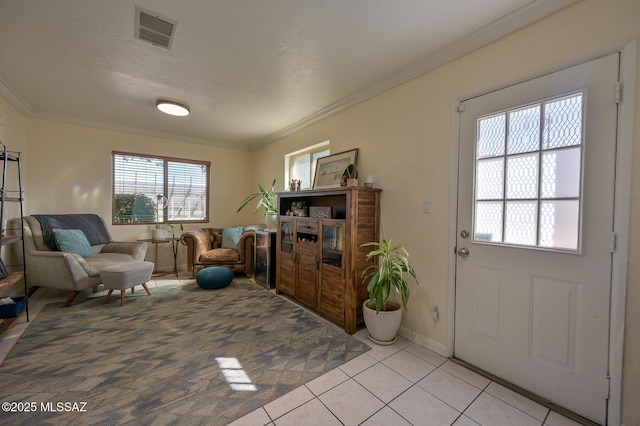sitting room with baseboards, visible vents, light tile patterned floors, and crown molding