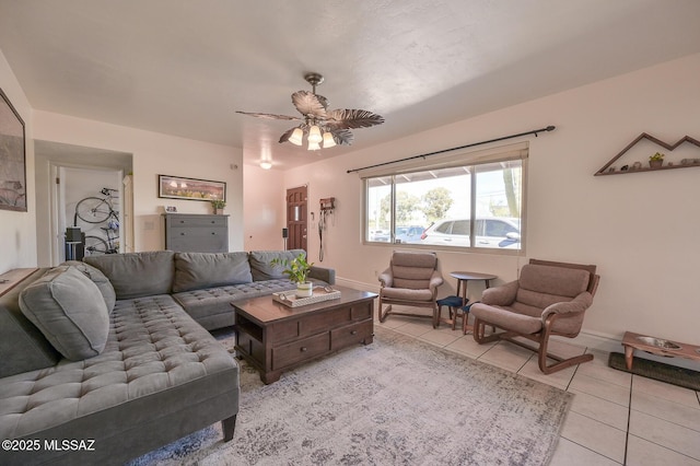 living area with baseboards, a ceiling fan, and tile patterned floors