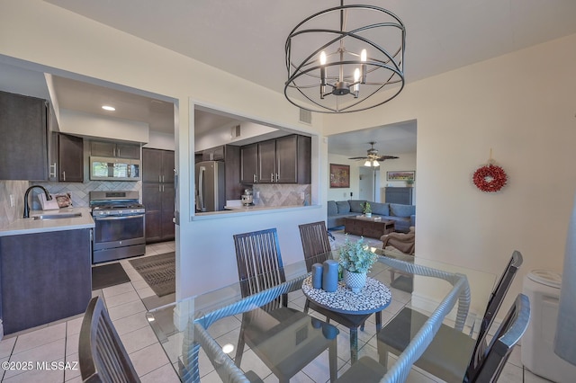 dining space with ceiling fan with notable chandelier and light tile patterned flooring