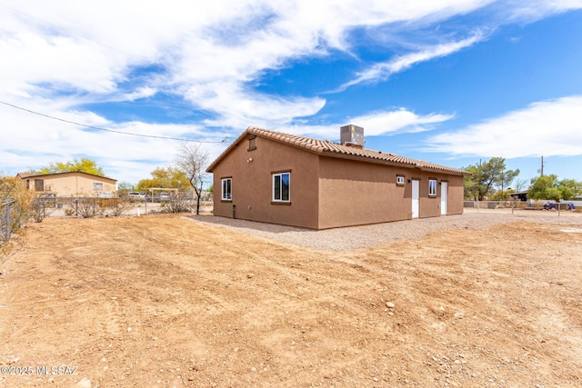 9008 W Bruce St, Tucson, AZ 85735 - view of side of property with a tiled roof, a chimney, stucco siding, and fence