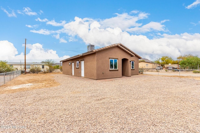9008 W Bruce St, Tucson, AZ 85735 - back of property with a tile roof, central AC unit, a chimney, fence, and stucco siding
