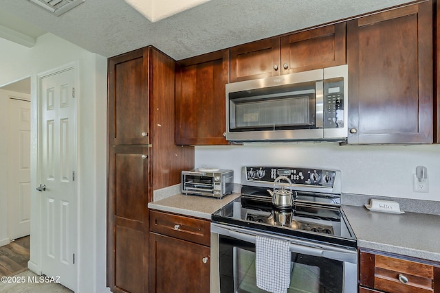 kitchen with a toaster, appliances with stainless steel finishes, and visible vents