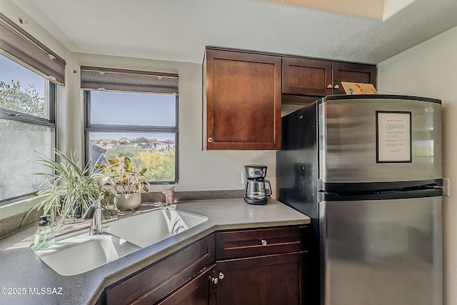 kitchen featuring freestanding refrigerator and a sink