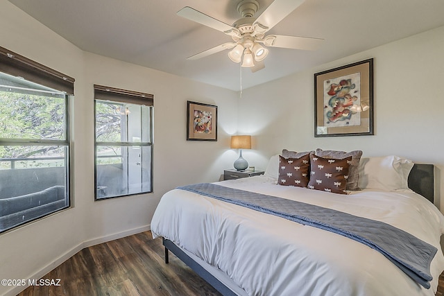bedroom with dark wood-type flooring, a ceiling fan, and baseboards