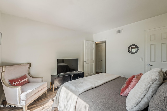 bedroom featuring wood finished floors and visible vents