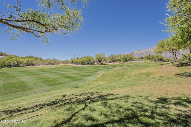 surrounding community with a lawn, a mountain view, and golf course view