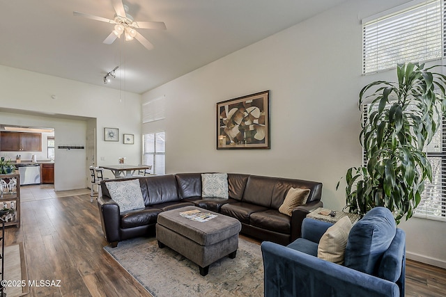living area featuring ceiling fan, a wealth of natural light, and dark wood-style floors