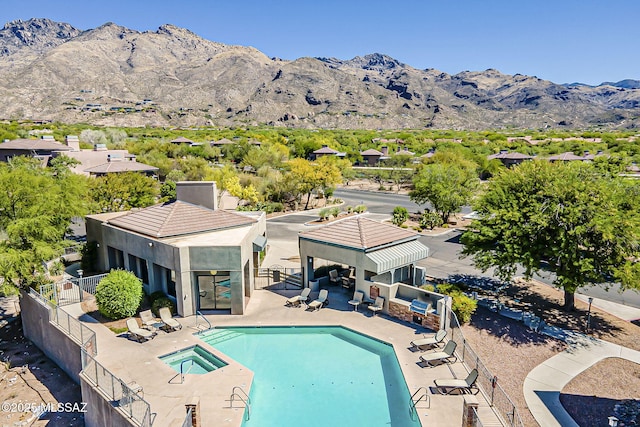 community pool featuring fence, a patio, a gazebo, a hot tub, and a mountain view