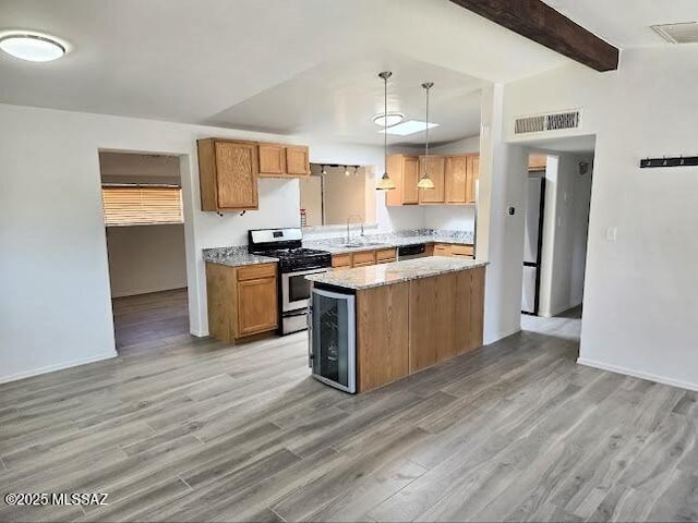 4743 E Scarlett St, Tucson, AZ 85711 - kitchen featuring appliances with stainless steel finishes, brown cabinets, light wood-type flooring, a sink, and visible vents
