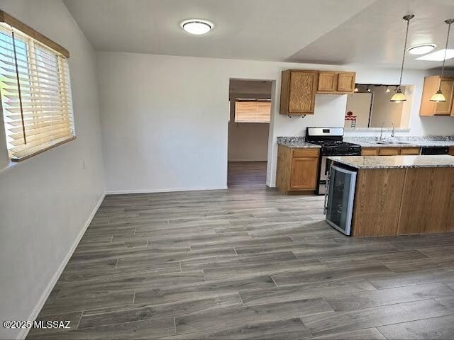 4743 E Scarlett St, Tucson, AZ 85711 - kitchen with a wealth of natural light, stainless steel gas range oven, brown cabinets, and baseboards