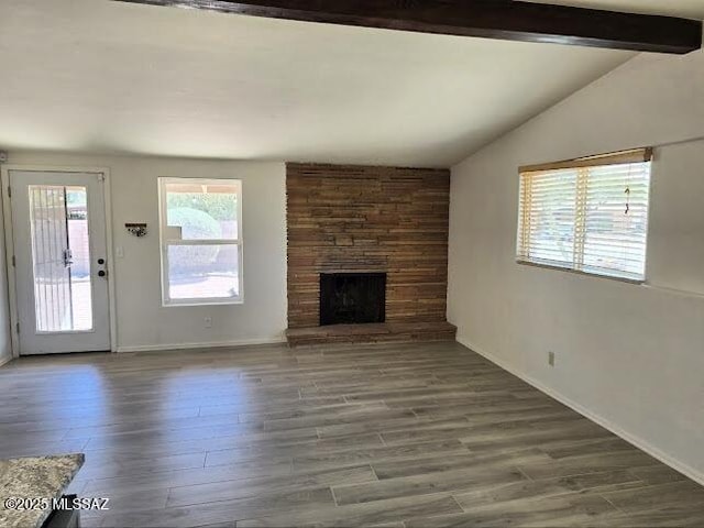 4743 E Scarlett St, Tucson, AZ 85711 - unfurnished living room featuring baseboards, lofted ceiling with beams, wood finished floors, and a fireplace