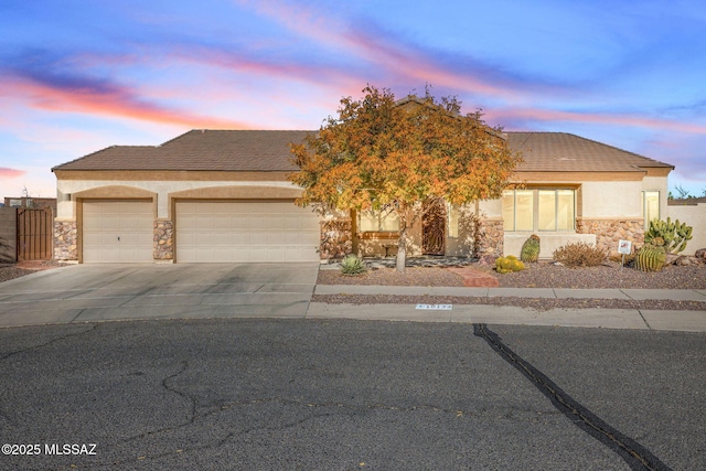 view of front facade with a garage, stucco siding, concrete driveway, and stone siding