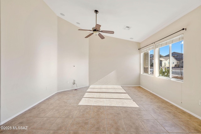 spare room featuring visible vents, baseboards, ceiling fan, light tile patterned floors, and vaulted ceiling