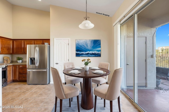 dining room featuring light tile patterned floors and high vaulted ceiling